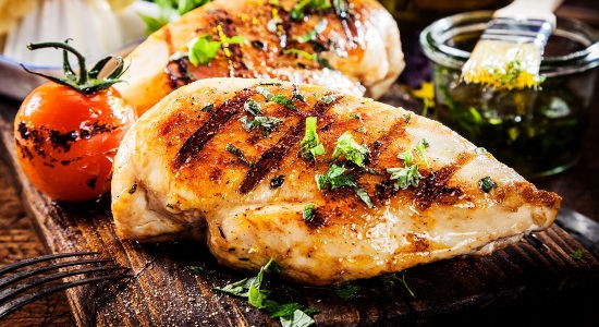 Marinated grilled healthy chicken breasts cooked on a summer BBQ
